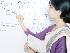 a woman is writing on a whiteboard