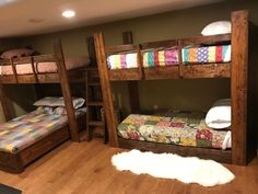 bunk beds in a room with wood flooring and white rugs on the floor