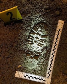 a ruler is laying on the ground next to some dirt