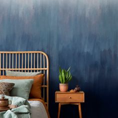 a bed with a wooden headboard next to a night stand and potted plant