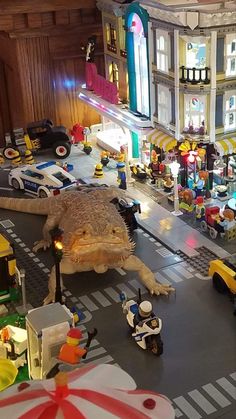 a toy city with cars, trucks and people on the street at night in legoland