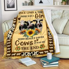 cow blanket with sunflowers and cows on it sitting on the floor in front of a couch