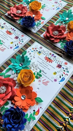 colorful paper flowers are on the table with cards and other things to make them look like they have been folded