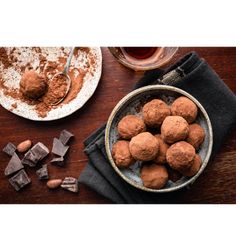 chocolate truffles in a bowl next to some cocoa chunks and a glass of tea