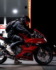 a man riding on the back of a red motorcycle