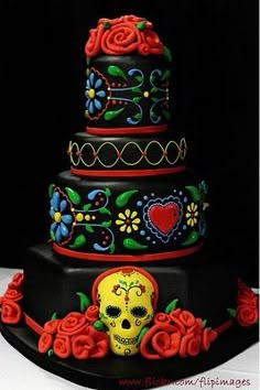 a triple layer cake decorated with sugar skulls and roses