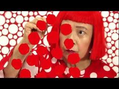 a woman with red hair and polka dots on her face is making an odd face