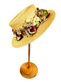 Romantic and elegant vintage style boater straw hat adorned with a composition of quality fabric flowers in shades of green and purple, attached to a 50 millimeter grosgrain ribbon. Made with 8/9 millimeters natural straw braid. Measurements in centimeters are 34 x 32. Crown height 9. Brim length 7. These measurements may have some slight variation depending on the size of the hat. For its elaboration we only use very good quality and resistant straw braids. In our workshop in the Pyrenees we se Vintage Straw Boater Hat For Garden Party, Handmade Vintage Hat Bands For Kentucky Derby, Retro Wide Brim Straw Hat For Spring, Vintage Adjustable Hat Bands For Vacation, Vintage Fedora Straw Hat For Garden Party, Vintage Straw Hat For Spring Garden Party, Vintage Short Brim Mini Hats For Country Events, Vintage Handmade Straw Hat For Garden Party, Bohemian Straw Hat With Short Brim For Garden Party