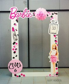 a barbie doll is standing in front of a photo frame with the word barbie on it