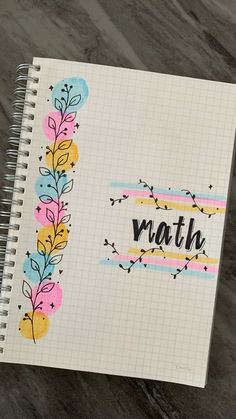 a notebook with the word math written on it and colorful flowers in front of it