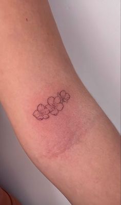 a small flower tattoo on the arm