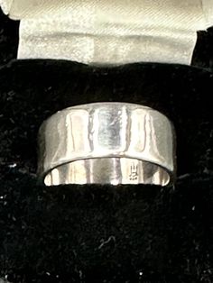 a silver ring sitting on top of a black velvet box