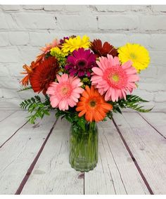 a vase filled with lots of colorful flowers