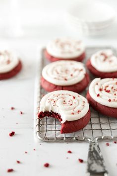 red velvet cookies with white frosting on a cooling rack