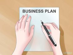 two hands are writing on a business plan