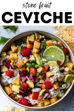 a bowl filled with fruit and salsa next to tortilla chips on the side