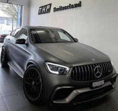 a grey mercedes glc parked in front of a building