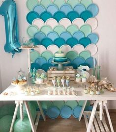 a white table topped with lots of cake and desserts next to a blue balloon