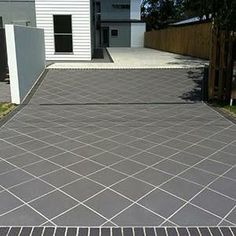 a brick paved driveway in front of a house