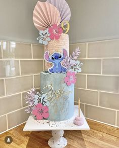 a blue cake with pink and purple flowers on top