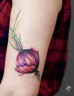 a woman's arm with a red onion tattoo on it