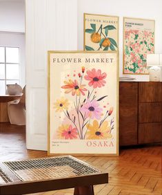 there are two posters on the wall in this living room, one is for flowers market and the other is for osak