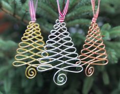 two ornaments hanging from a christmas tree with red and white ribbons on it's ends