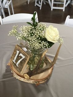 a vase filled with flowers sitting on top of a wooden slice next to an open book