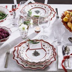 the table is set with dishes, silverware, and other holiday decorating items