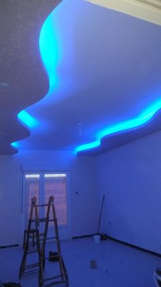 an unfinished room with blue lighting and white walls