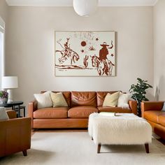 a living room filled with furniture and a painting on the wall