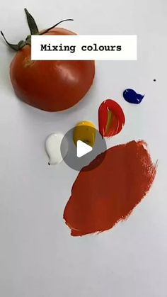 a tomato sitting on top of a white table next to some paint chips and a piece of paper