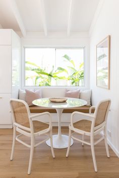 a white table and chairs in front of a window