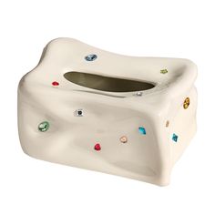 a white ceramic tissue holder with multi colored stones on it