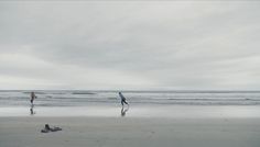 two people are walking on the beach with their feet in the sand