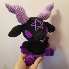 a crocheted black and purple stuffed animal with horns