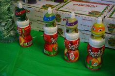 several bottles of food sitting on top of a green tableclothed surface next to stacks of pizza boxes