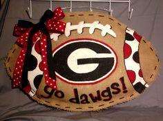 a football shaped door hanger with the word go dawgs painted on it