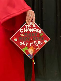 a woman in a red graduation gown holding a sign that says time changes makes misstoakes get messy