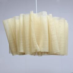 a bunch of white fabric hanging from a hook on a string with some strings attached to it