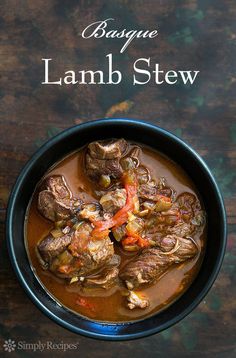 a bowl filled with lamb stew on top of a wooden table