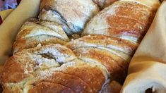 a basket filled with lots of bread on top of a table