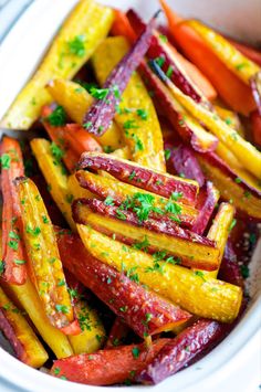 a white bowl filled with cooked carrots and parsley