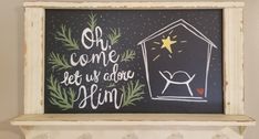 a chalkboard with the words oh came let us adore him and a nativity scene