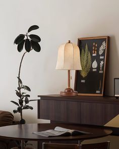 a living room with a table, lamp and pictures on the wall