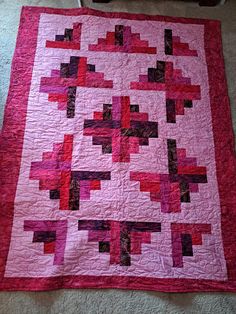 a pink and black quilt on the floor