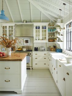 a white kitchen with lots of counter space and cabinets on both sides of the room