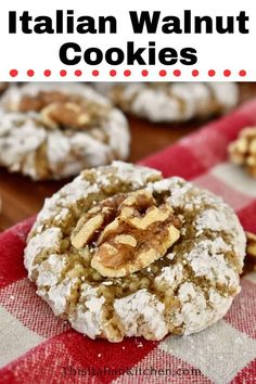 cookies with walnuts and powdered sugar are stacked on top of each other in front of a checkered tablecloth