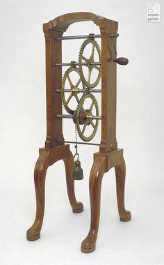 an old wooden clock with gears attached to it