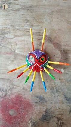 a clock made out of colored pencils sitting on top of a wooden table